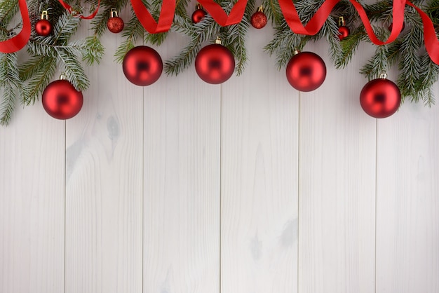 Kerstdecoraties, rode ballen op een witte houten tafel. Bovenaanzicht, kopie ruimte.