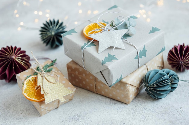 Foto kerstdecoratieve zelfgemaakte geschenkkistjes gewikkeld in bruin kraftpapier op een grijze betonnen achtergrond