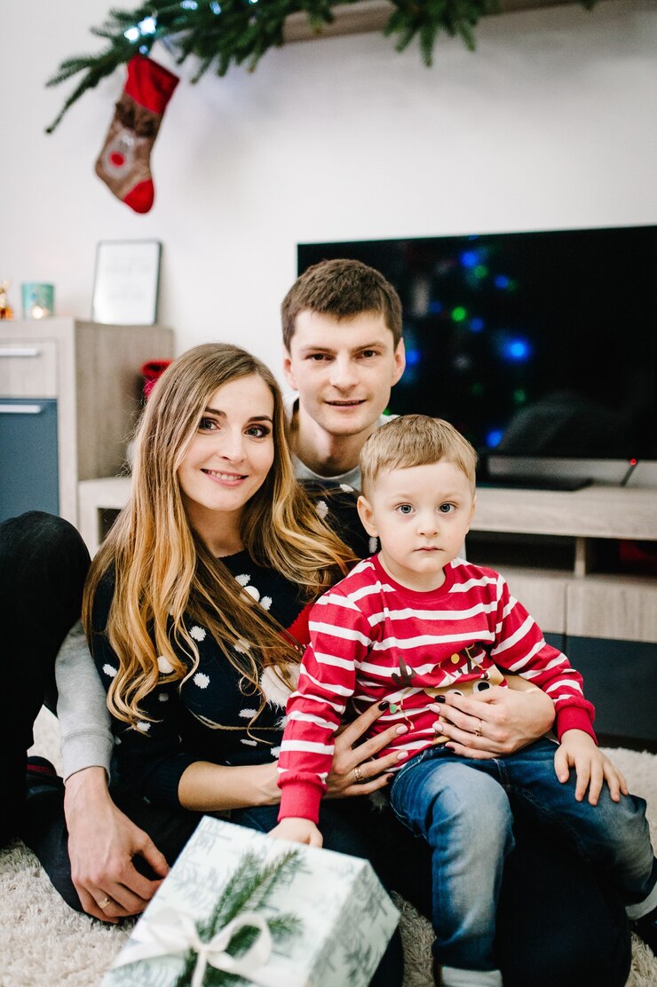 Foto kerstfamilie geven cadeau aanwezig in de buurt van de kerstboom binnenshuis.