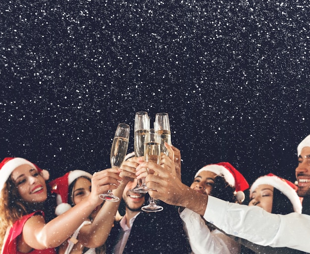 Kerstfeest tijd. Jongeren roosteren met champagnefluiten, rammelende glazen en feliciteren elkaar met nieuwjaar, kopieer ruimte