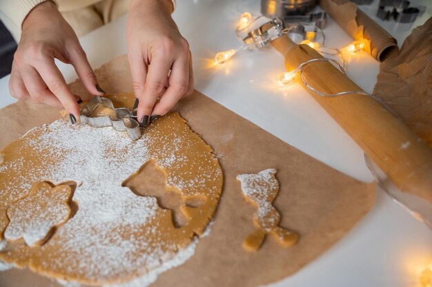 Foto kerstgebakjes maken van deeg met je handen in een vorm