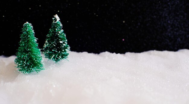 Kersthuisdecoratie met kleine handgemaakte geschenkdoos in een besneeuwd miniatuur groenblijvend bos en bokehlicht voor kopieerruimte