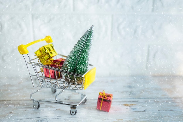 Kerstinkopen seizoen concept mini winkel winkelwagen trolley vol geschenkdoos op bakstenen achtergrond