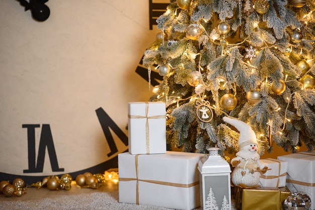 Kerstkaart met prachtige besneeuwde kerstboom en gouden speelgoed en guirlande versieren huis