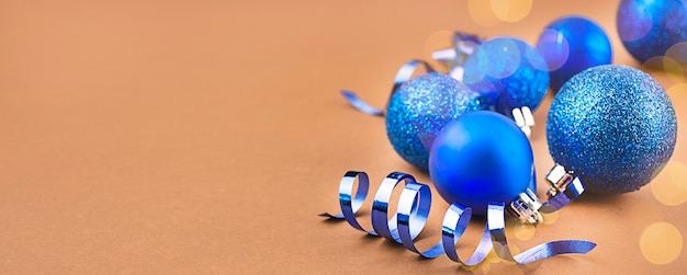 Kerstkaart van blauwe ballen op een bruine achtergrond met hoogtepunten. Kerstvakantie samenstelling.