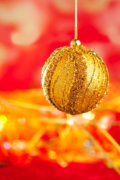 Kerstkaart van gouden bauble en rood vervagen