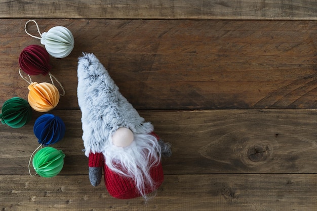 Kerstkabouter met handgemaakte papieren bollen. Houten achtergrond. Ruimte kopiëren. Bovenaanzicht.