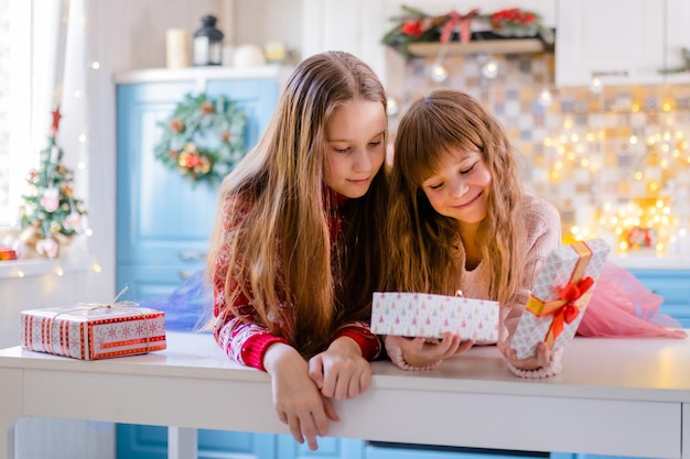 Kerstkind meisje opening doos in keuken binnenverlichting