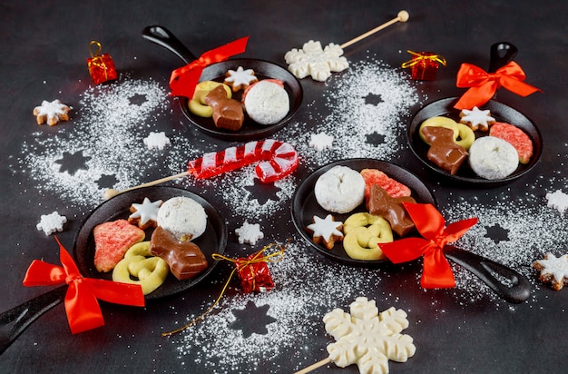 Kerstkoekjes, chocolade in mini-koekenpannen op suikerpoedertafel