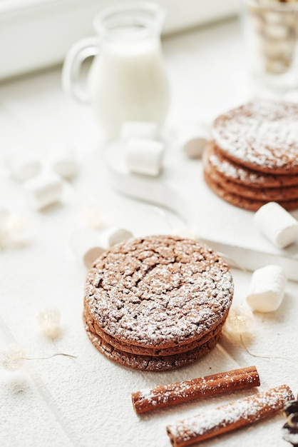 Kerstkoekjes en marshmallows op een wit bij het raam