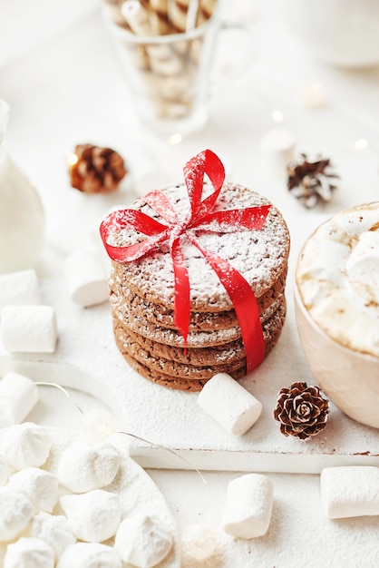 Kerstkoekjes en marshmallows op een wit bij het raam