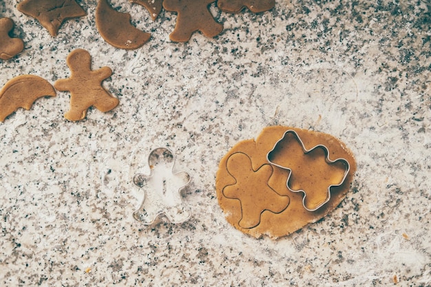 Kerstkoekjes maken met peperkoekjes op de keukentafel met feestverlichting.