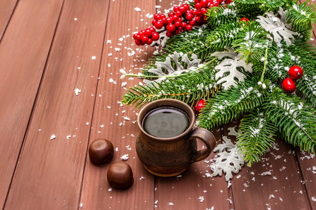 Kerstkoffie, dennenboom, verse bladeren, chocoladesuikergoed en kunstmatige sneeuw.