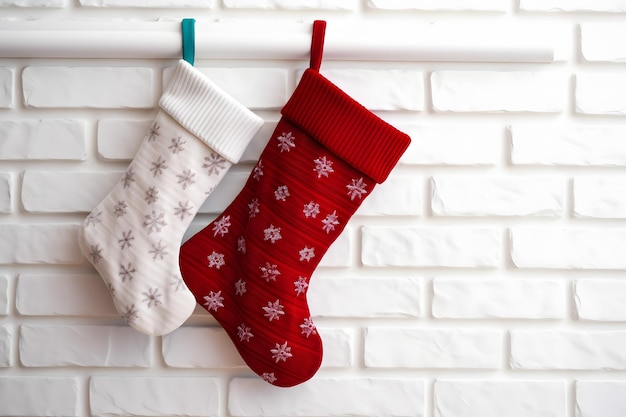 Kerstkousen hangen op een witte bakstenen muur voor feestelijke feestdecoratie