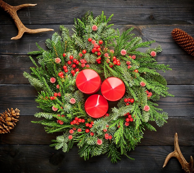 Kerstkrans en kaarsen op houten achtergrond