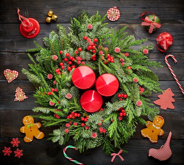 Kerstkrans en kaarsen op houten achtergrond