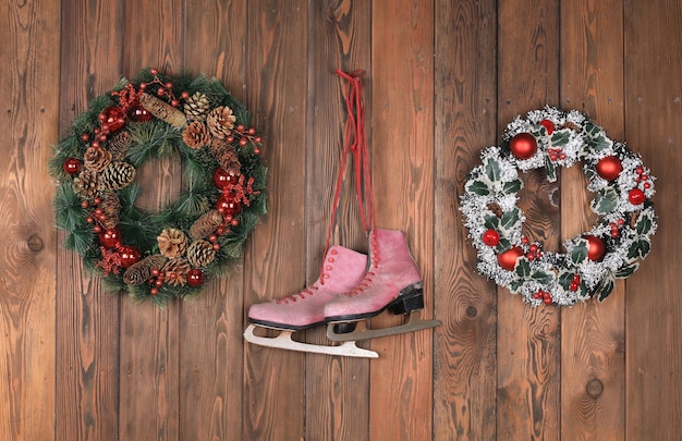 kerstkrans en oude schaatsen op houten muur