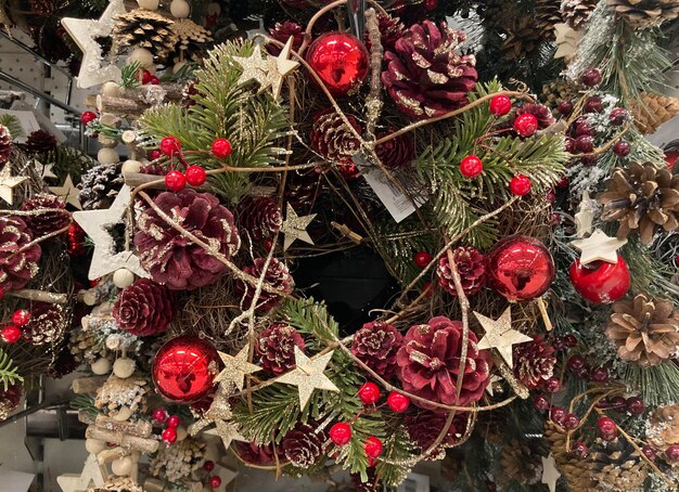 Kerstkrans gemaakt van natuurlijke dennen takken die aan een witte muur hangen