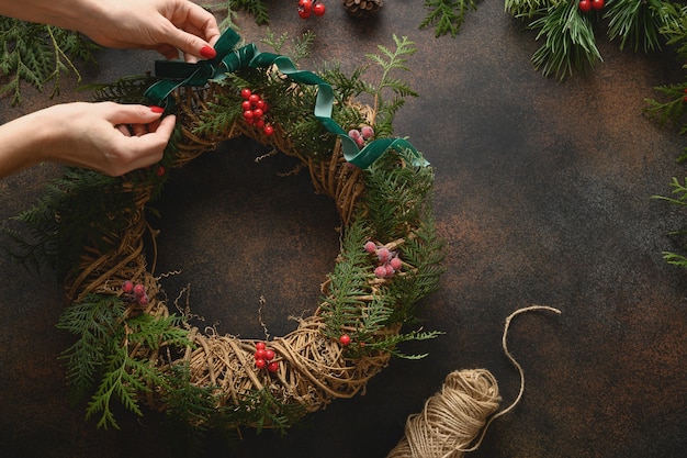 Kerstkrans van verse natuurlijke sparrentak met rode bessen op bruine achtergrond nieuwjaar xmas