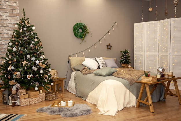 Kerstkransen aan de muur in de slaapkamer ingericht voor de viering van de wintervakantie. Feestelijke woondecoratie.