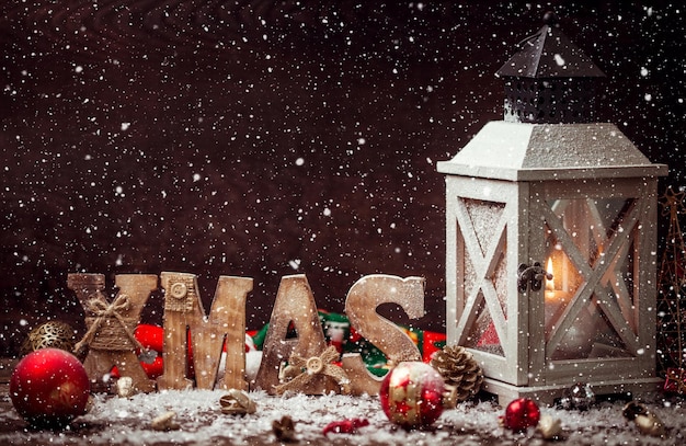 Kerstlantaarn op besneeuwde tafel met feestelijke decoratie.