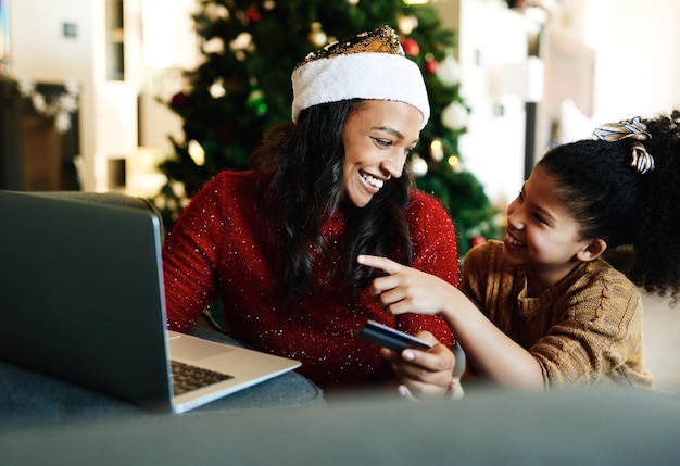 Kerstlaptop en creditcard met moeder en meisje voor online winkelcadeau of digitale betaling Fintech e-commerce en aankoop met moeder en kindklant voor feestvakantie en kerstdeal