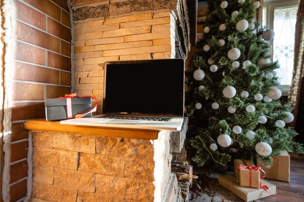 Kerstlaptop met kerstboom in een oud houten huis