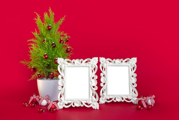 Kerstlay-out op een rode achtergrond een kerstboom en twee witte frames