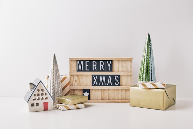 Kerstletterbord met spelling Prettige Kerstdagen en Gelukkig Nieuwjaar met inpakcadeaus en kerstversieringen