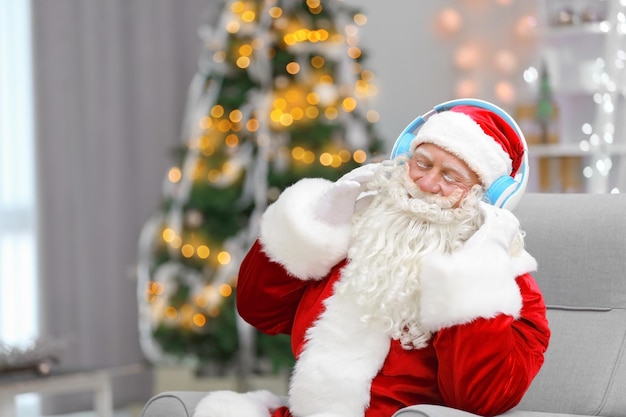 Kerstman die naar muziek luistert in de woonkamer