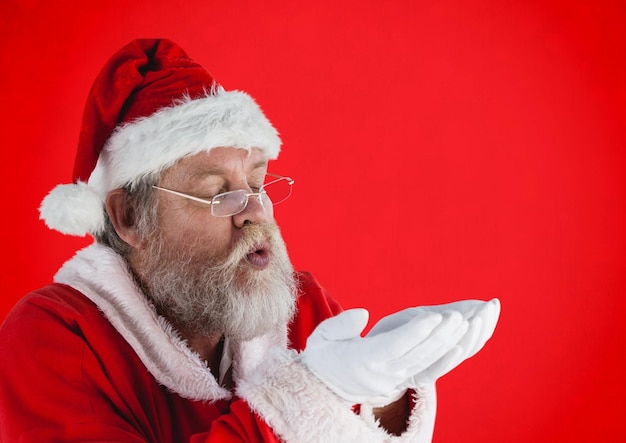 Kerstman doet alsof hij denkbeeldige sneeuw blaast