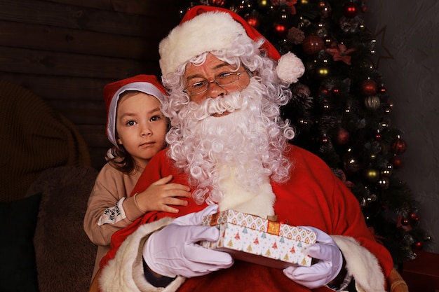 Kerstman en kind thuis. Kerstcadeau. Familie vakantie concept.