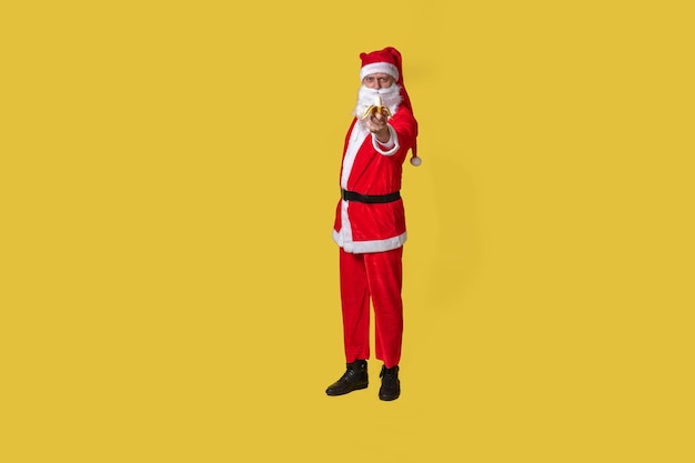 Kerstman geel grappige stijl bretels traditie kerst senior man pak mensen Rode rijpe tijd eet een banaan met zijn rechterhand