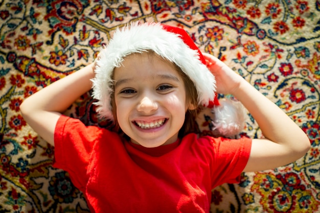Kerstman leuk jong geitje op tapijt die thuis glimlachen