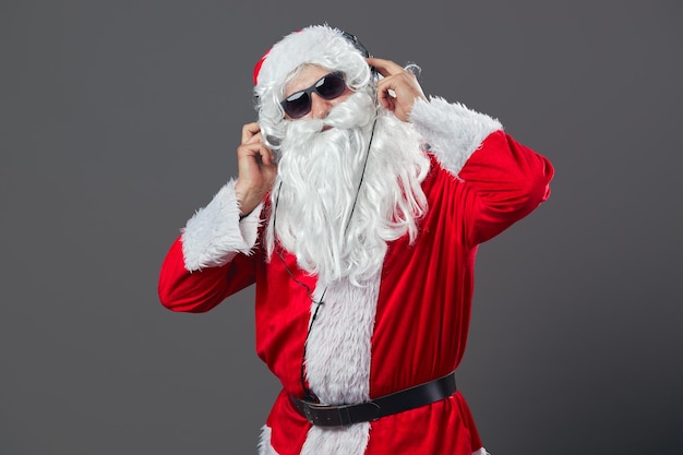 Kerstman met een lange witte baard en in zonnebril en koptelefoon