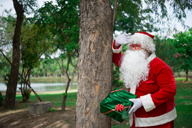 Kerstman met geschenkdoos in het bosThailand mensenVerzonden geluk voor kinderen Vrolijk kerstfeest Welkom bij de winter