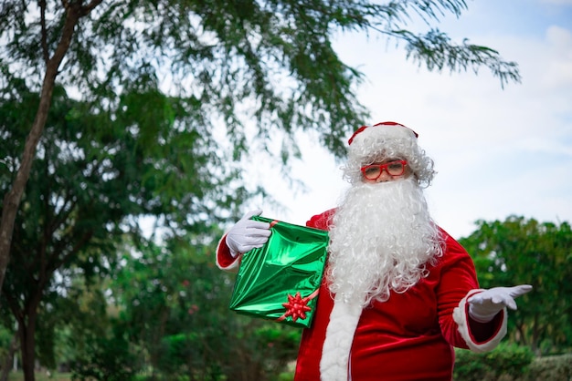 Kerstman met geschenkdoos in het bosThailand mensenVerzonden geluk voor kinderen Vrolijk kerstfeest Welkom bij de winter