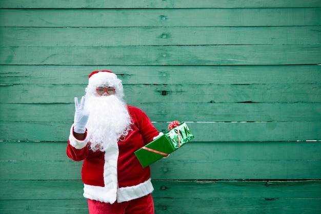 Foto kerstman met geschenkdoos op hout achtergrond thailand mensen verzonden geluk voor kinderen vrolijk kerstfeest welkom bij de winter