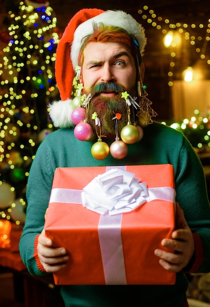 Kerstman met versierde baard voor het nieuwe jaar bebaarde man met kerstcadeau nieuwjaarsgeschenkdoos