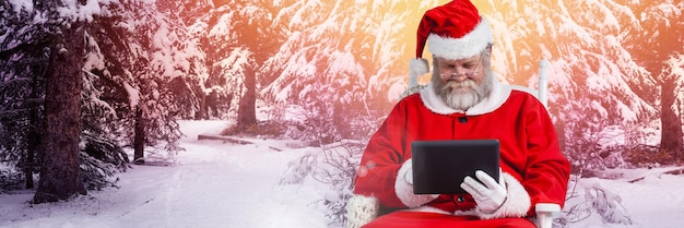 Kerstman met winterlandschap met tablet