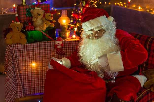 Kerstman open rode zak om te kijken Vrolijk kerstfeestGeluk voor de kinderenWelkom in de winterGelukkig nieuwjaarslicht van zak