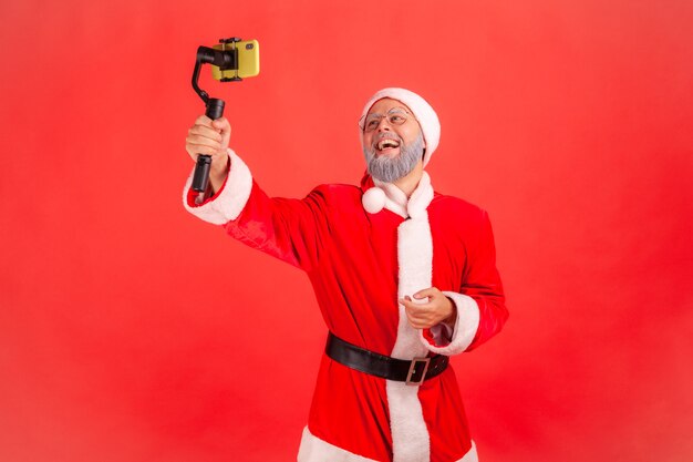 Kerstman praat met volgers, houdt steadicam in handen, livestream.