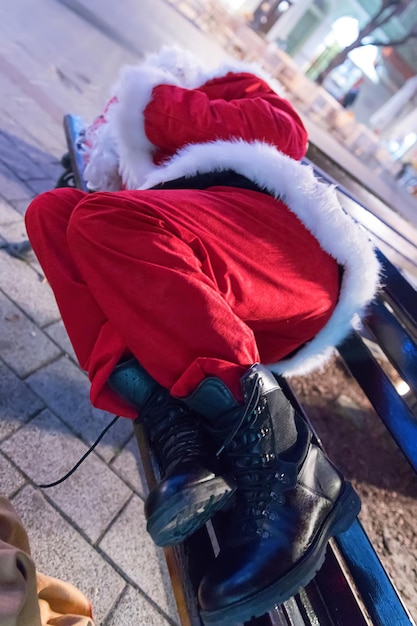 Kerstman slaapt op de bank en ontspant na een lange nacht werken.