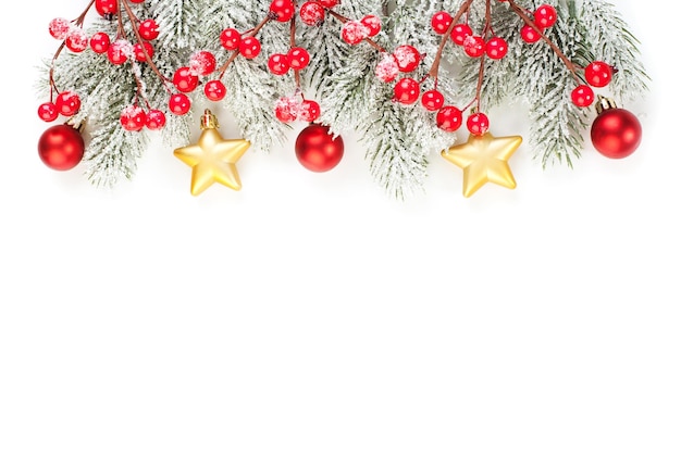 Kerstmis achtergrond gemaakt met groenblijvende boomtakken rode hulst bessen goud en rode kerstballen geïsoleerd op een witte achtergrond Plat lag kopie ruimte Nieuwjaar of Xmas concept grens
