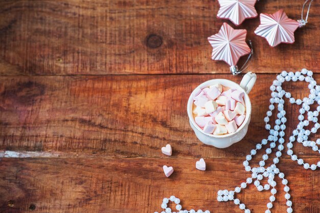 Kerstmis achtergrond. Kerstballen, kopje koffie met marshmallows op een houten ondergrond. Kader, kopieer ruimte