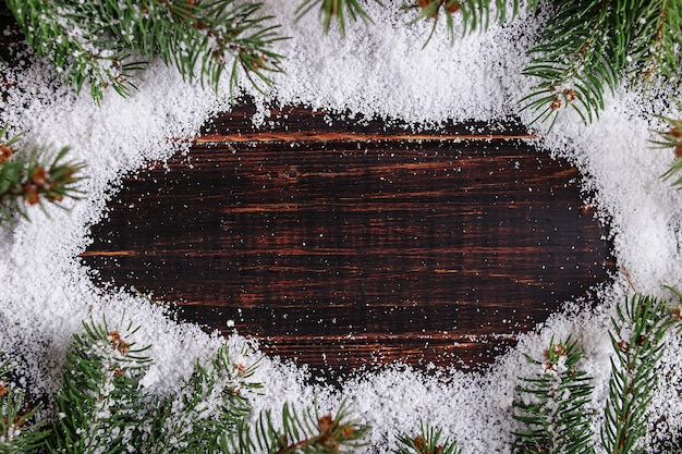 Kerstmis achtergrondkader, groene Kerstbomen op een houten lijst, gestormd door witte sneeuw, exemplaarruimte, hoogste mening.