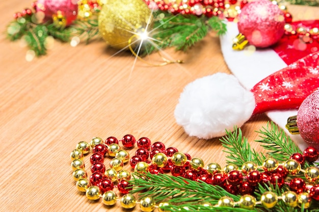 Kerstmis en Nieuwjaar achtergrond Kerstballen kralen en hoed met kerstboom takken