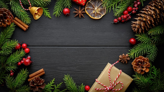 Kerstmis en Nieuwjaar achtergrond. Spar boomtakken en kerstversiering op zwarte houten achtergrond met kopie ruimte