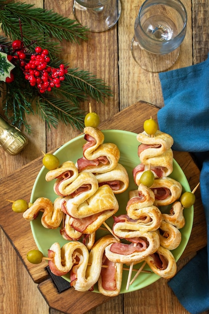 Kerstmis en Nieuwjaar eten Vakantiesnack bladerdeeg Kerstboom met olijf en spek Bovenaanzicht