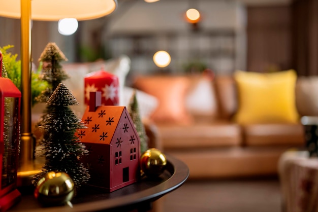 Foto kerstmis en nieuwjaar feestelijke achtergrond rode kleur huismodel decoratieve items op bijzettafel in woonkamer appartement residentieel met licht bokeh geluk vreugdevolle gebeurtenis